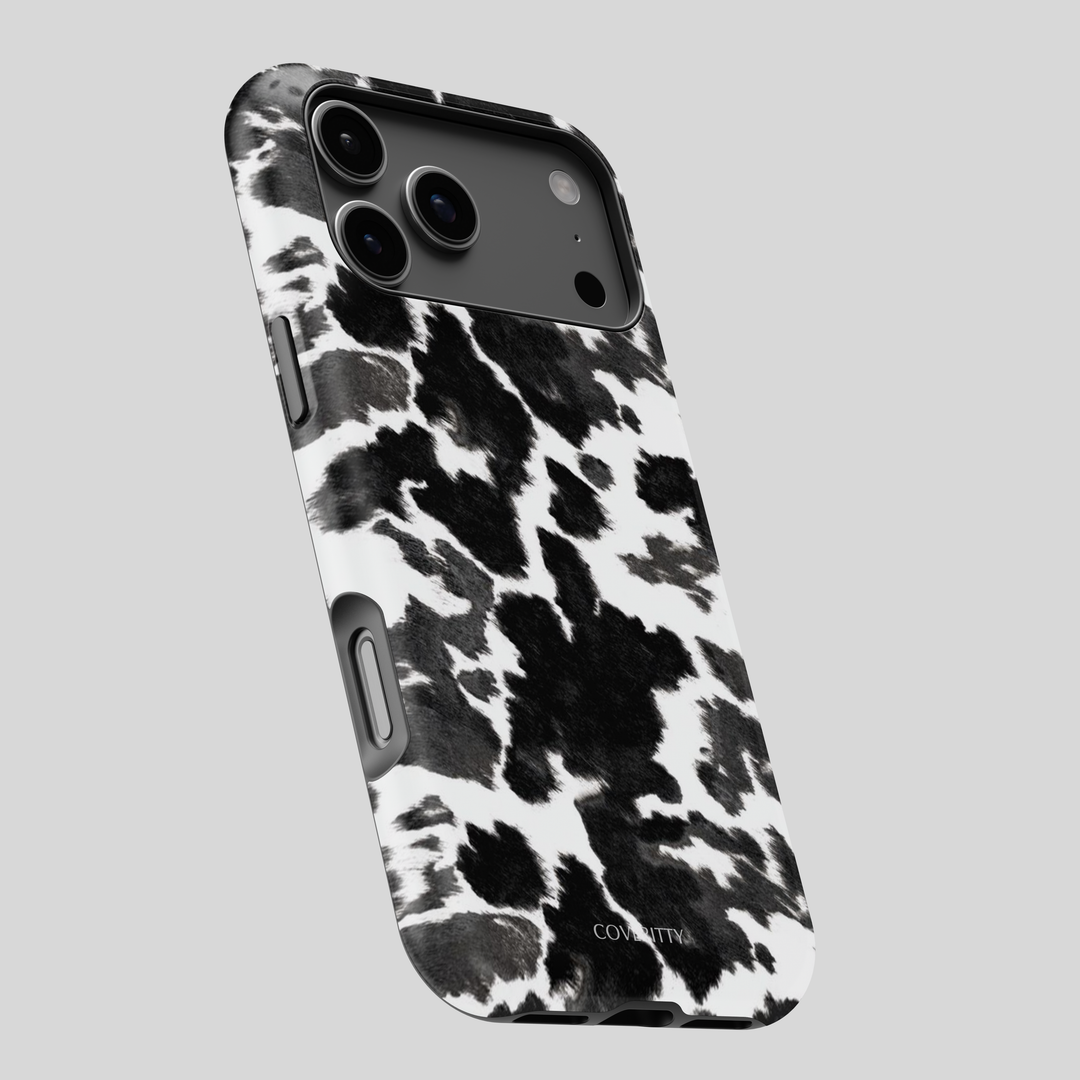 Phone case with black and white cow print pattern on a gray background
