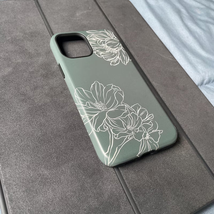 Green phone case with floral design on a gray surface